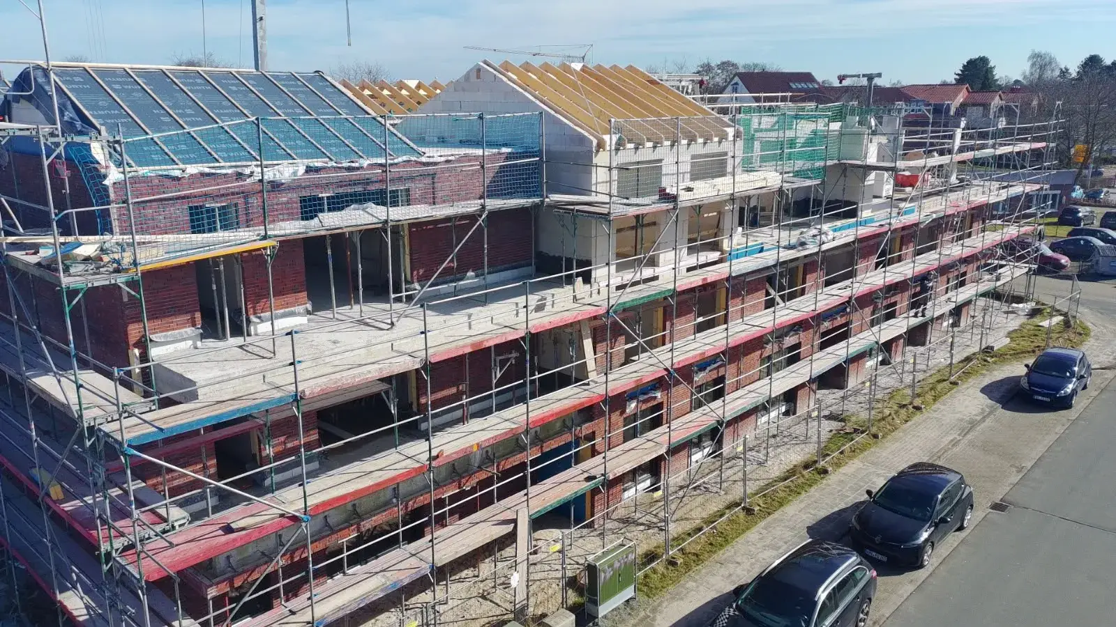 Mehrgeschossiger Neubau mit Fassadengerüst und im Bau befindlichem Dachstuhl