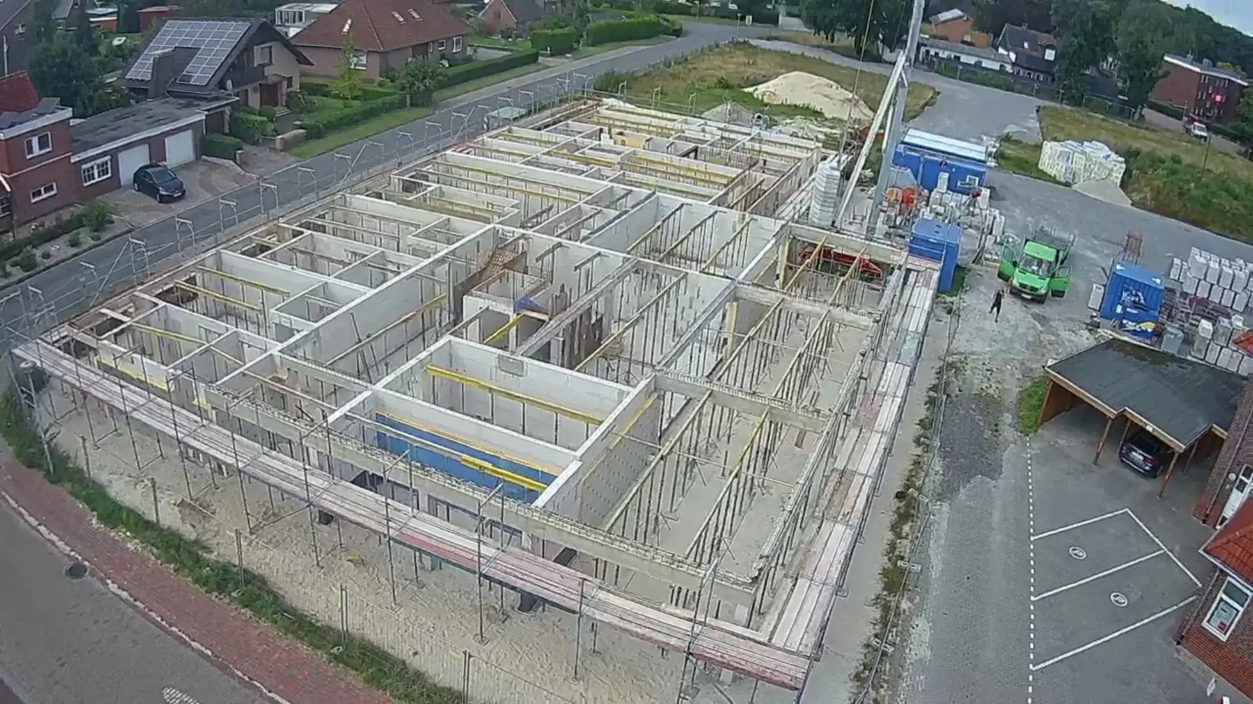 Blick von oben auf einen großflächigen Rohbau mit umlaufendem Gerüst